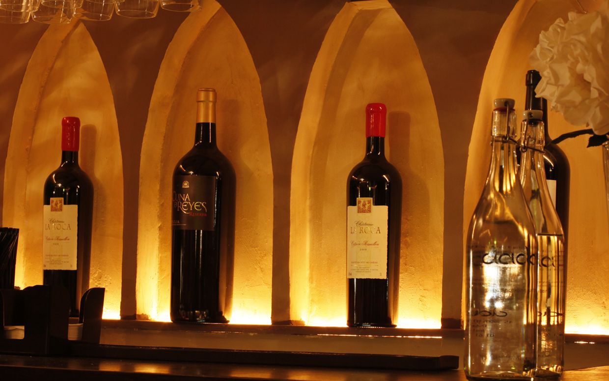 Lit arches with wine bottles